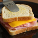 Croque Monsieur Sandwich in der Pfanne braten.